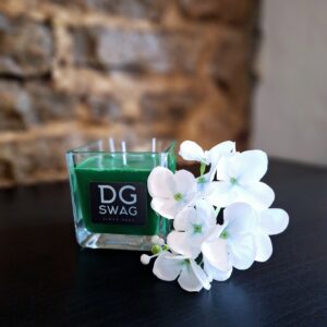 bougie verte sur meuble avec fleur blanche